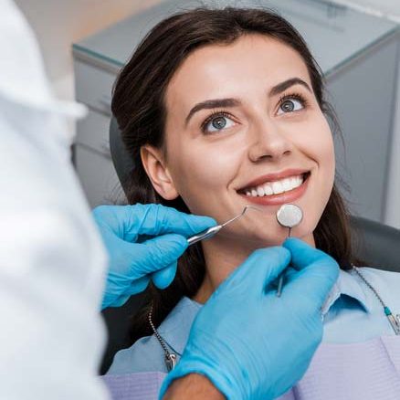 Woman smiling as she has a dental exam